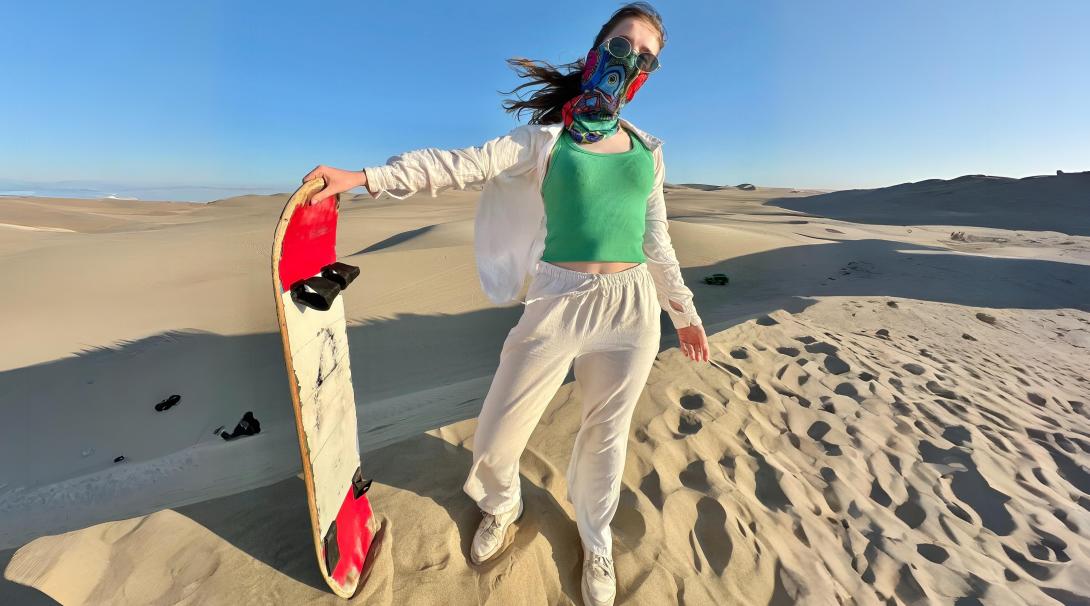 Sandboarding down golden dunes in Peru